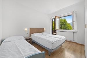 two beds in a room with a window at Residence Lagorai in Tesero +64 photos