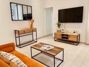 salon z kanapą i telewizorem z płaskim ekranem w obiekcie "Garenne 2" Cosy 3 pièces quartier haut climatisé avec patio ! w mieście Sète +14 zdjęć