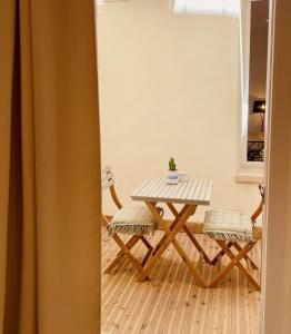 stół i krzesła w salonie z zasłoną w obiekcie "Garenne 2" Cosy 3 pièces quartier haut climatisé avec patio ! w mieście Sète