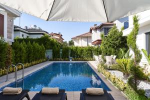a swimming pool in a backyard with an umbrella at Edem Villa Park in Agva