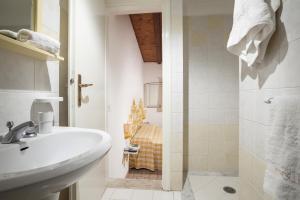a white bathroom with a sink and a shower at Le Roccette Club in Tropea