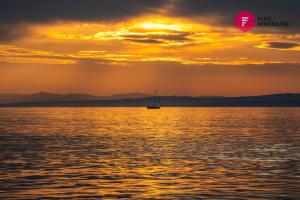 una barca a vela in acqua al tramonto di La Maison de l'Échouerie on Chaleur Bay Seaside a Bonaventure