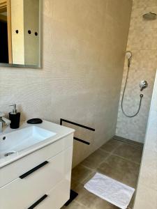 a bathroom with a white sink and a shower at Sea view Mandre in Mandre +15 photos
