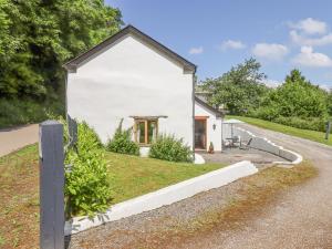a small white house on a road at Peace Cottage in South Molton