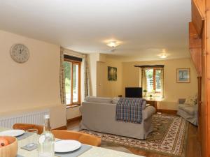 a living room with a couch and a table at Peace Cottage in South Molton