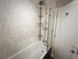a white bathroom with a shower and a tub at Sunnyside in Camber +14 photos