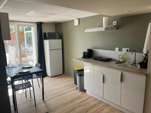 a small kitchen with a table and a refrigerator at Logis de Bois Vert in Bressuire