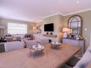 a living room with a wooden table and a tv at The Farmhouse in Clacton-on-Sea