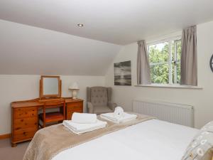 a bedroom with a bed and a dresser and a mirror at Dove Cottage in South Molton