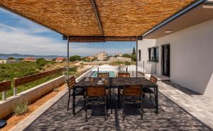 ザダルにあるVilla Pava ZadarVillasのバルコニーにテーブルと椅子が置かれたパティオ