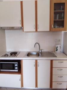 a kitchen with white cabinets and a sink at Emmanouil in Kythira