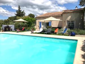 a swimming pool in front of a house at Le Patio Fleuri in Lorgues