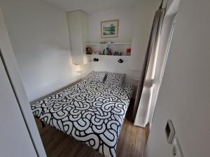 una camera da letto con un letto con un motivo bianco e nero di Holiday home Melisa a Mozirje