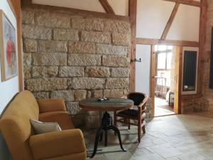 a living room with a stone wall and a table at Ferienwohnung Galerie in Bad Schandau