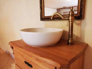 a sink and a faucet on a wooden table with a mirror at Ferienwohnung Galerie in Bad Schandau