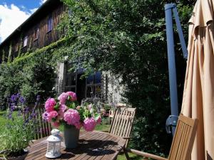 a table with a vase of flowers and two chairs at Ferienwohnung Galerie in Bad Schandau