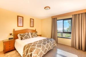 a bedroom with a bed and a large window at Macdonald Doña Lola Resort in La Cala de Mijas