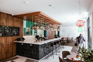 a bar in a restaurant with a person standing in the room at Ibis Luxembourg Airport in Luxembourg