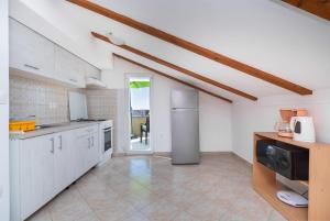 ヴーシにあるApartment Anaの白いキャビネットと窓付きの広いキッチン