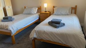 two beds with towels on them in a room at The Duke William in Haxey