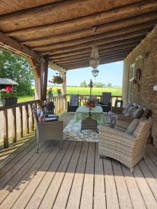 a wooden deck with couches and chairs on it at B&B Wijdzicht in Wolsum
