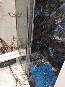 una doccia con una porta in vetro e un pavimento blu di Sikalafo1 a Płock