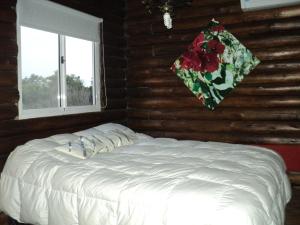 Una cama blanca en una habitación con ventana. en Cabañas El Secreto, en Monte Hermoso 19 fotos más