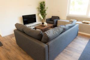 a living room with a couch and a tv at Dohann1 Zentrum, Messehalle, Stationnah & Privatparkplatz in Dortmund