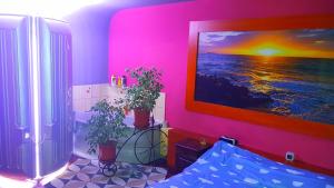 a pink room with two plants and a painting on the wall at Apartament Park Śląski in Katowice