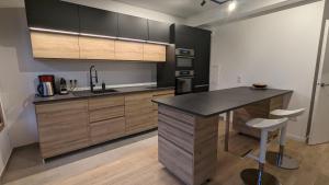 a kitchen with wooden cabinets and a black counter top at La Clé de Thierry in Le Vésinet