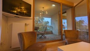 a living room with a table and chairs and a balcony at La Clé de Thierry in Le Vésinet
