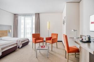 ein Hotelzimmer mit einem Bett und zwei Stühlen in der Unterkunft IntercityHotel Dresden in Dresden + 22 Fotos