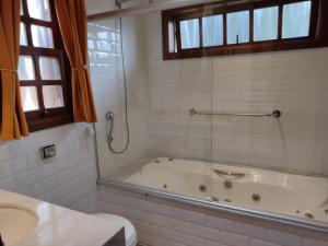 a bathroom with a tub and a toilet and a sink at Chalé Recanto Bela Vista in Monte Verde +35 photos