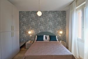 a bedroom with a large bed with blue pillows at Appartamento bellissima vista lago, spiaggia privata,nuovo in Bardolino