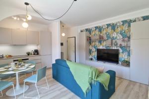 a living room with a blue couch and a table at Appartamento bellissima vista lago, spiaggia privata,nuovo in Bardolino +12 photos