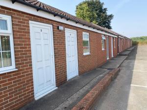 a row of white doors on a brick building at The Duke William in Haxey