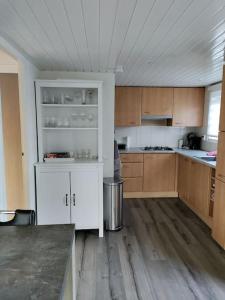 a kitchen with white cabinets and a counter top at Chalet midden in de natuur! in Anloo