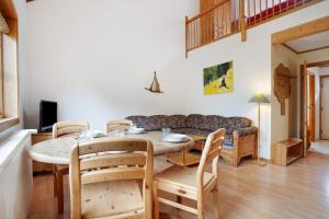 a living room with a table and chairs and a couch at Haus Albatros Wohnung 4 in Ostseebad Koserow