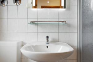 a white bathroom with a sink and a toilet at Haus Albatros Wohnung 4 in Ostseebad Koserow +28 photos