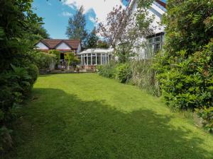 a garden with a house and a lawn at Akila in Oldham