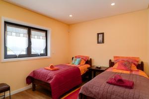 a bedroom with two beds and a window at Porto Vivenda em Lever-casa inteira in Lever +34 photos