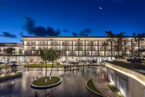 a large building with palm trees in front of it at Marupiara Resort by Wish in Porto De Galinhas +54 photos