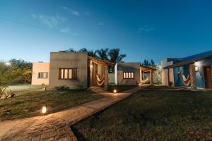 a house with lights on the yard at night at Vila Aracatí Pousada in Santo Amaro