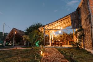an outdoor patio with a wooden table and lights at Vila Aracatí Pousada in Santo Amaro +17 photos