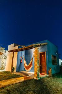 a blue house with a curtain on the side of it at Vila Aracatí Pousada in Santo Amaro