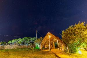 a wooden barn with lights on it at night at Vila Aracatí Pousada in Santo Amaro