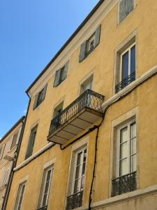 a building with a balcony on the side of it at La Halte des Arènes de Nîmes Nude Beauté du Minimalisme in Nîmes