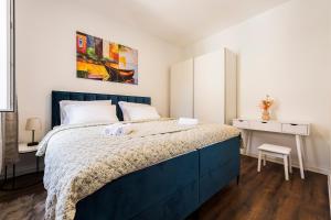 - une chambre avec un lit bleu et un bureau dans l'établissement Marijano Central Apartments, à Split