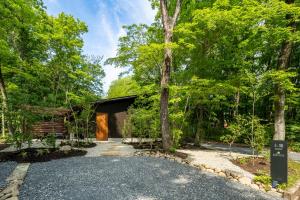 a driveway leading to a cabin in the woods at 森の宿り 土庵まるやま in Nasu