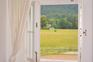 an open window with a view of a field at Ferienwohnungen am Bullachberg in Schwangau